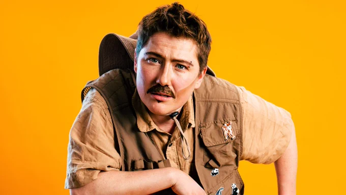 A moustachioed drag king in safari-style khakis