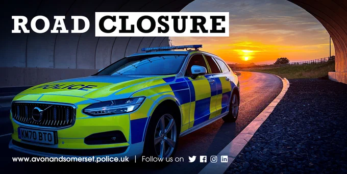 The image shows a police car traveling through a tunnel as the sun sets with the words 'road closure' in the top-left corner.