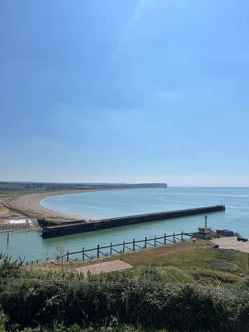 View from Newhaven Fort looking out to sea on a sunny summer's day, with the harbour arm and turquoise blue water.  
