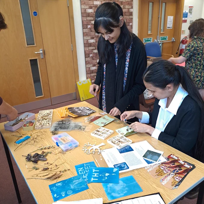Two people getting involved in cyanotype printing activity 