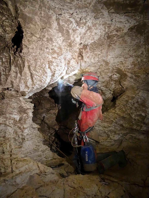 One of the cavers drilling into the wall of the cave.