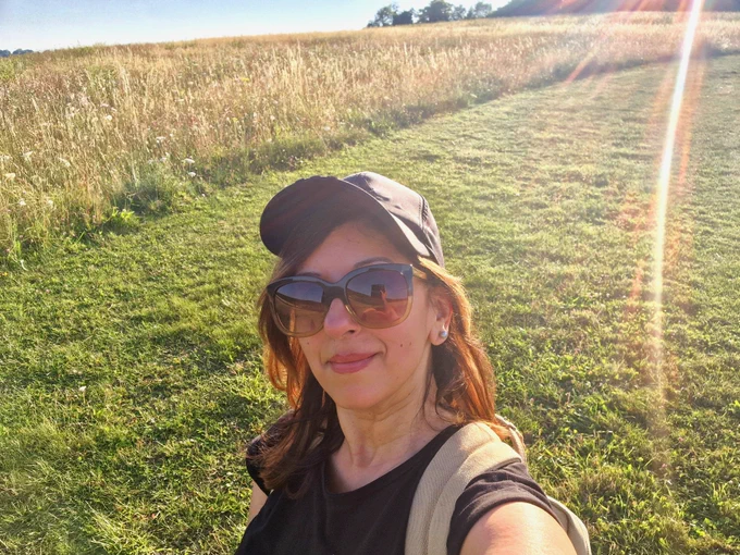 Indian woman standing under sunrays in the Chilterns. 