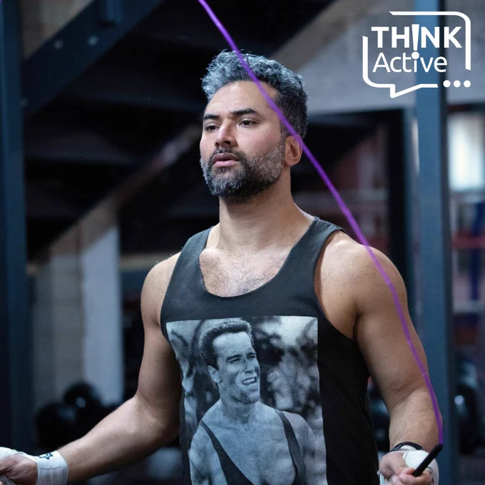 [Man Skipping below the Think Active logo, wearing a shirt that shows image of Arnold Schwarzenegger smiling.]