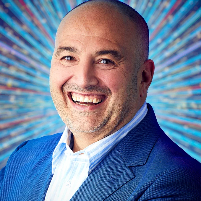 Wynne Evans wears a blue suit jacket over a blue and white shirt