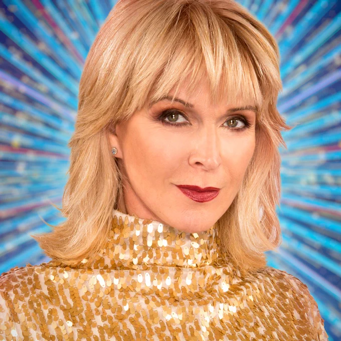 Toyah Willcox wears a sparkling high necked outfit, with gold sequins