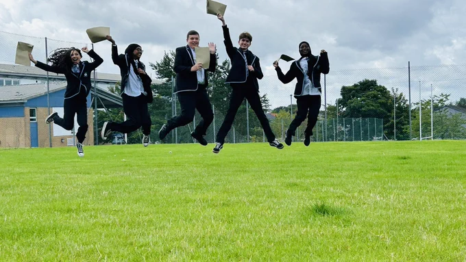 Smithycroft young people jumping in the air celebrating exam results