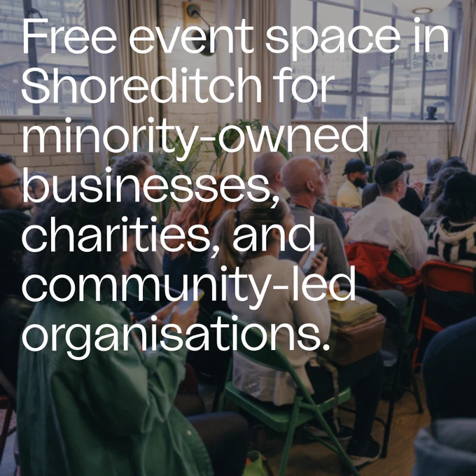 Text overlay: Free event space in Shoreditch for minority-owned businesses, charities, and community-led organizations. Background: an event audience in rows of folding chairs in ustwo's event space, a large and airy room with big windows and white painted brick walls.