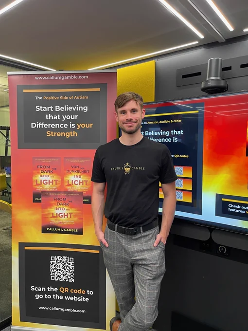 Callum standing in front of his roller banner and presentation slides while getting ready to be interviewed.