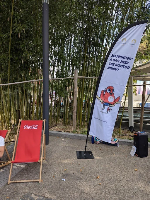 Un transat coca-cola à côté d'une bannière olympique invitant à bouger plus