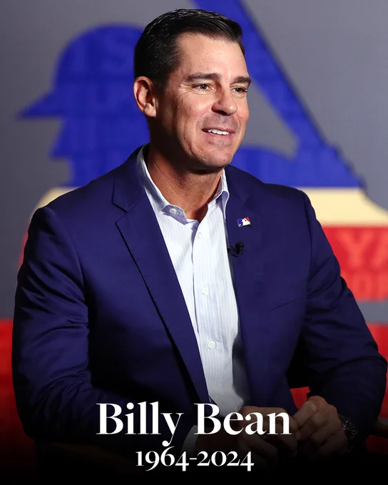 Billy Bean 1964-2024
Pictured: A photo of Billy Bean sitting with the MLB logo behind him.