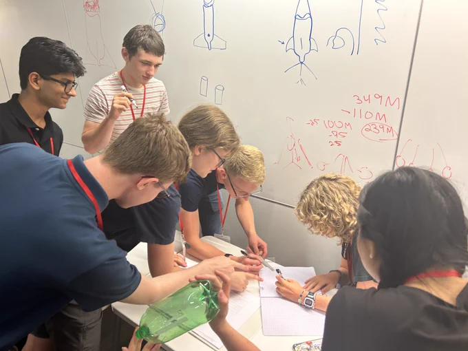 Scholars collaboratively working together on an engineering challenge