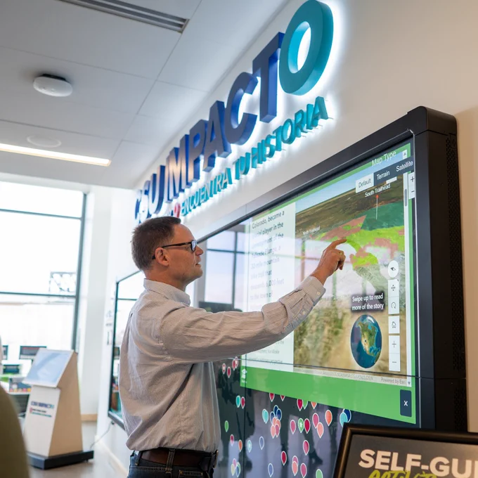 One person interacting with a large map on a large TV display
