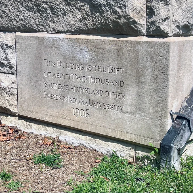A stone affixed to a building reads: "THIS BUILDING IS THE GIFT OF ABOUT TWO THOUSAND STUDENTS ALUMNI AND OTHER FRIENDS OF INDIANA UNIVERSITY 1906."