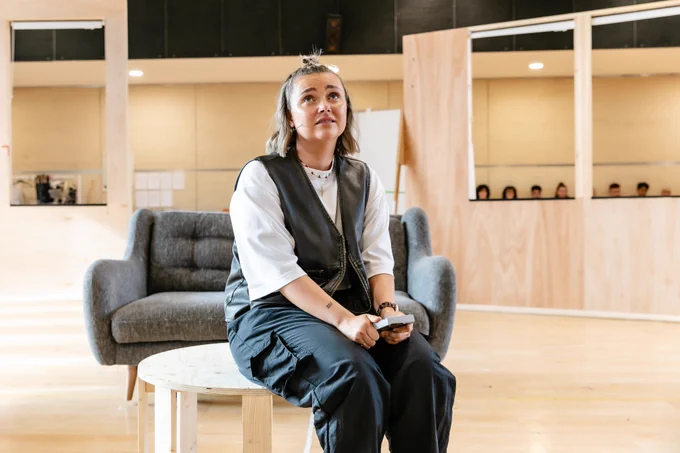 Leesa Tulley sits and looks like she is contemplating in rehearsals