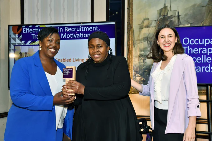 Aqua and Fiona accepting the awards smiling and standing beside the presenter.