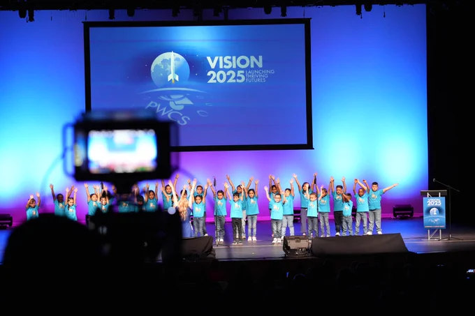Long distance photo of young students performing on a stage.