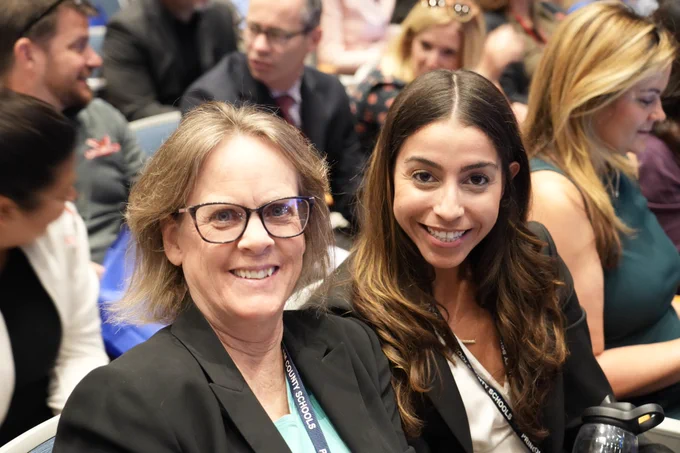 Two staff members smiling at the camera for a photo.