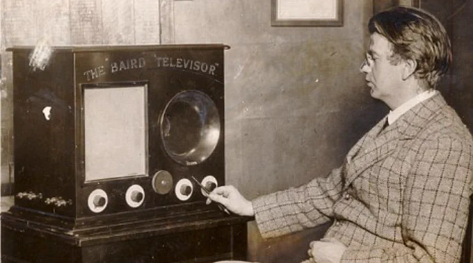 John Logie Baird sits in a suit in front of his television system, which was first successful in transmitting moving images in 1925. Credit: Royal Television Society