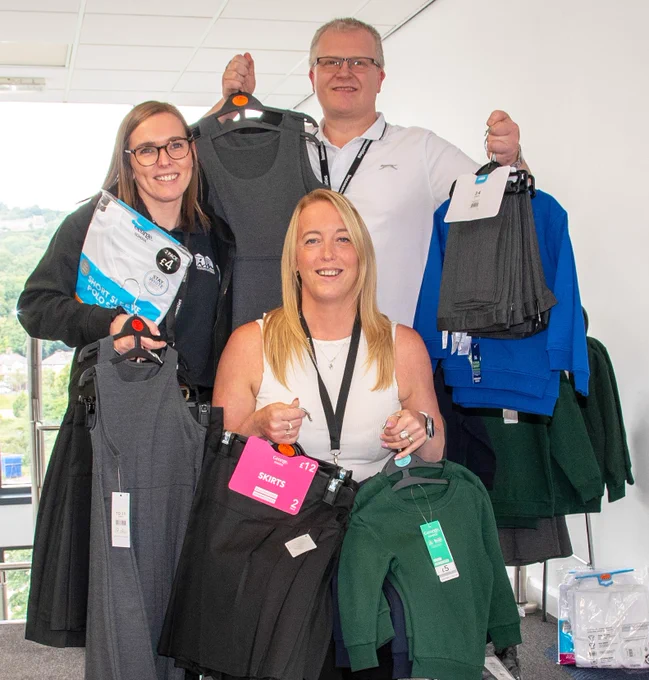 Staff from Incommunities holding school uniform