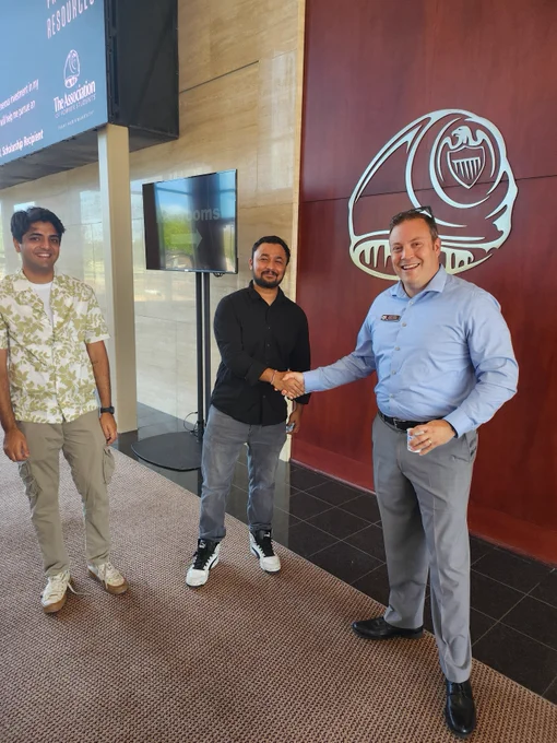 A Texas A&M student shakes hands with an employee of the Association of Former Students.