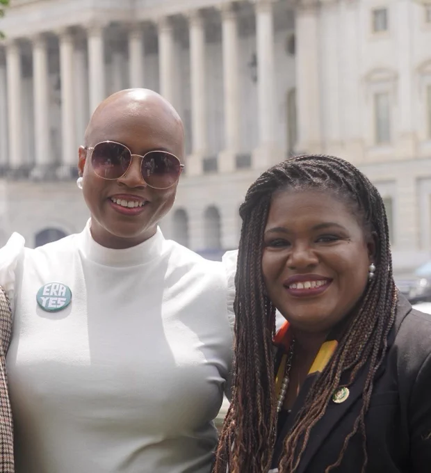 Rep. Pressley and Rep. Bush smile for a photo outside the Capitol building.