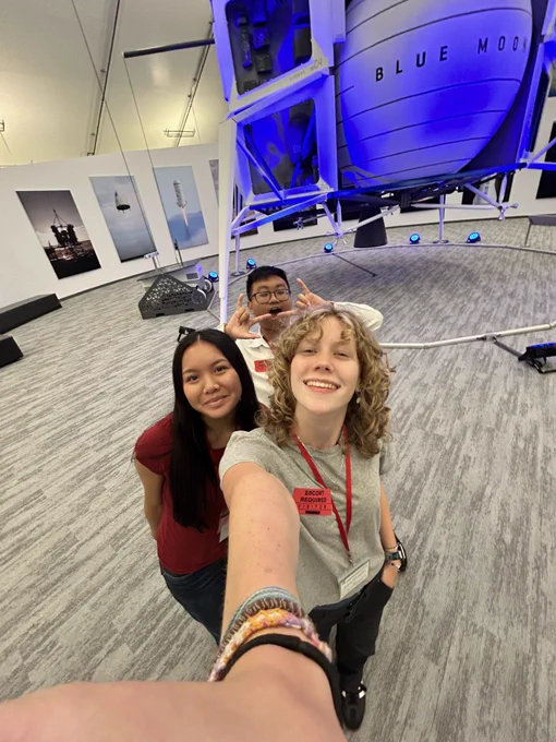 Selfie of students in front of blue moon lunar lander