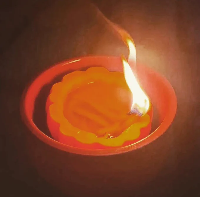 A homemade jhoth (diva), filled with ghee and a little cottom wick, lit during prayers