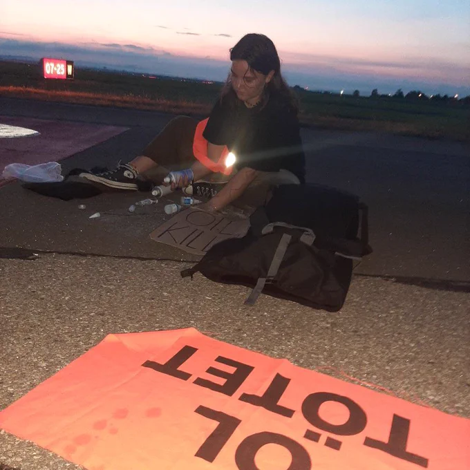 Regi mit OIL KILLS Bannern auf dem Rollfeld