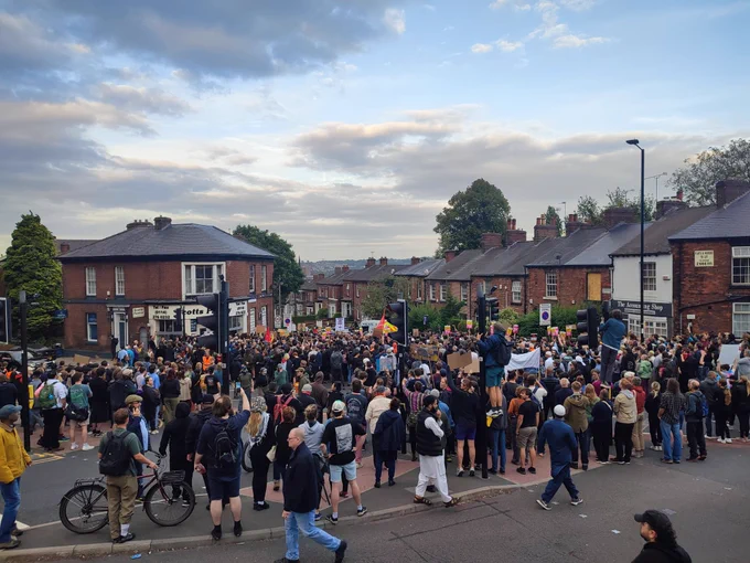 Large crowd of people in Wilkinson st stood outside white rose solicitors defending it