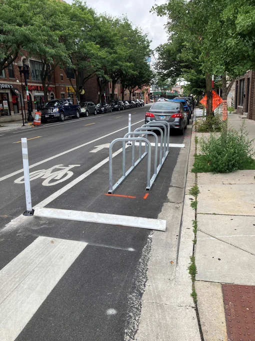 New on-street bike corral with protective curb stops and delineators in the daylight zone right up against a pedestrian crossing. 