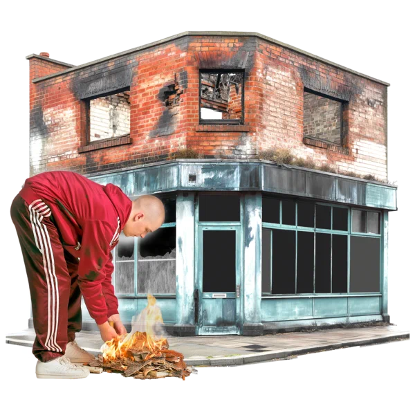 An image of a rioter setting a fire in front of a burnt out building 