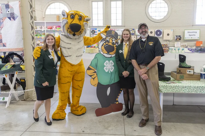 Three people pose with Truman the Tiger
