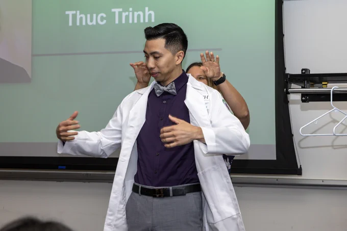 A Rush cardiac perfusion student receives their white lab coat.