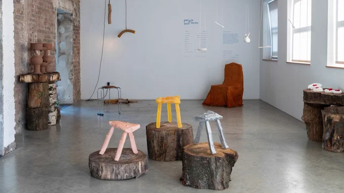 General room shot of a product and furniture exhibition, with stools and pottery made of various materials