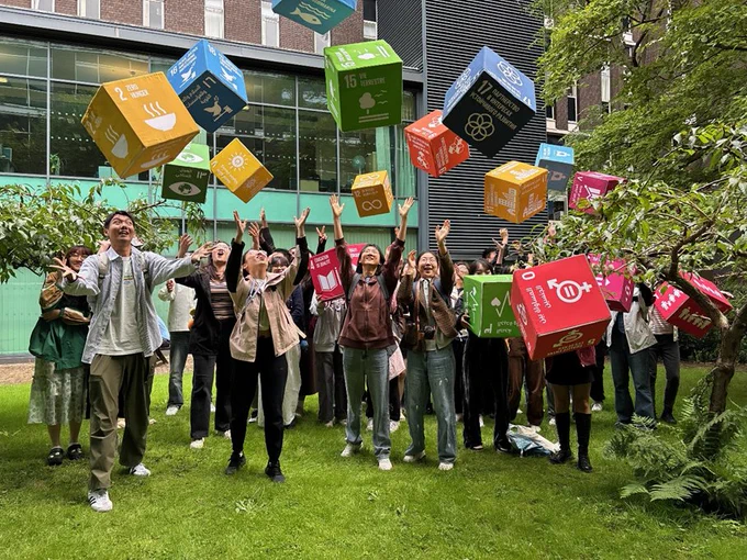 Group of students throwing SDG cubes in the air