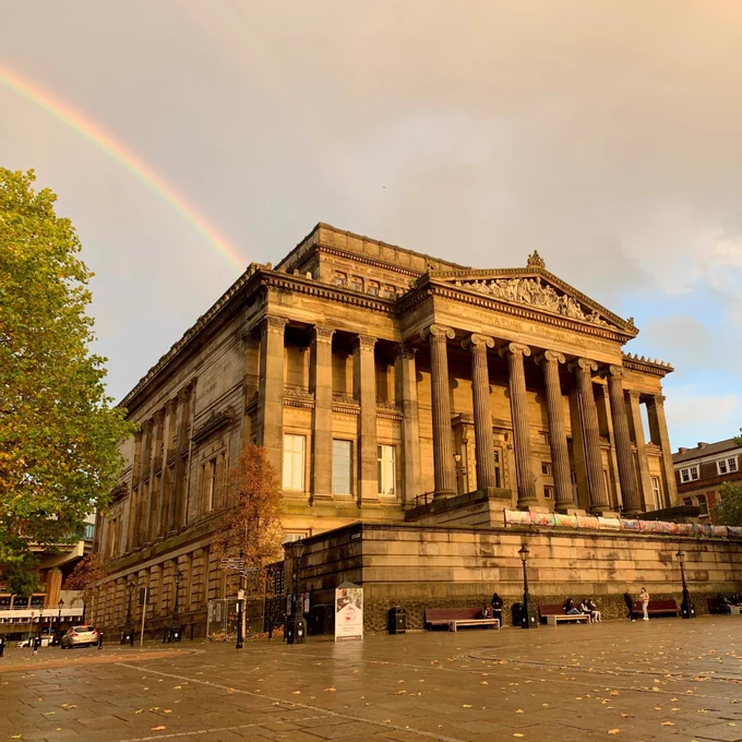 Image of The Harris with a rainbow visible behind the building.