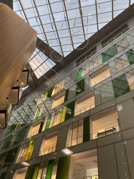 Sky seen through a glass roof in a building with coloured glass panels.