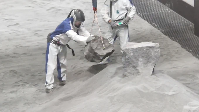 Mit Feingefühl werden die „Mondsteine“ positioniert.
Die LUNA-Halle ist inzwischen fast vollständig mit Regolith-Simulat gefüllt. Zusammen mit den Gesteinsbrocken kommt die Oberfläche dem Original schon sehr nahe.

Credit: DLR/ESA