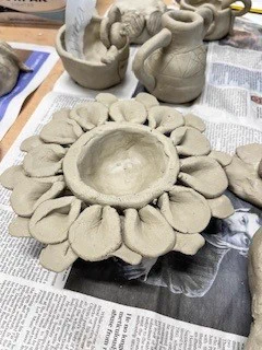 A collection of clay pots arranged neatly on a wooden table, showcasing their earthy tones and unique shapes.