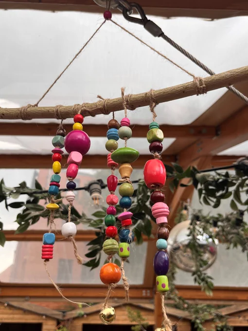 A wooden beaded hanging decoration featuring an array of colourful beads, adding a vibrant touch to any space.