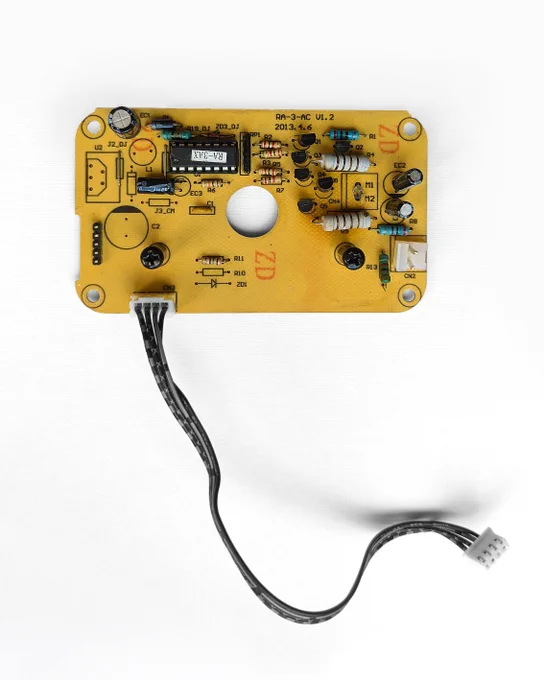 white background; brown-yellow electronic control panel with black cables and white connector