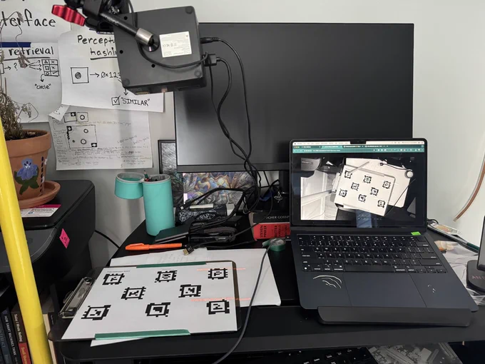 A showing a printout of 8 AprilTags and a laptop displaying the same view from above