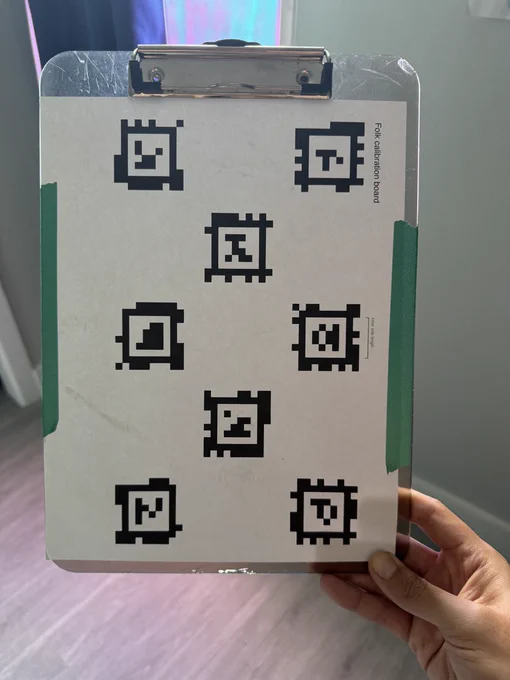 A clipboard with teal washi tape holding down a printout of 8 AprilTags