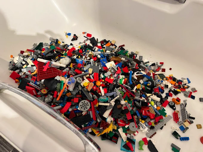 A colourful pile of Lego bricks in a white bathtub