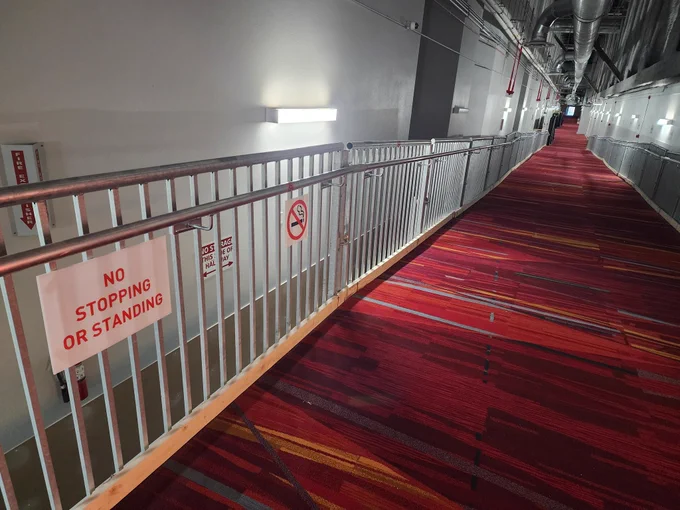 A sign indicating no stopping or standing in a hallway.