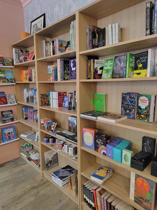 Bigglestones Bookshopの店内。木目調の本棚に本とタロットカードが並んでいる