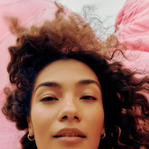 Photograph of the lovely English soul artist, Olivia Dean for her single album cover for her song Time, which is the featured song on FreeV.Com