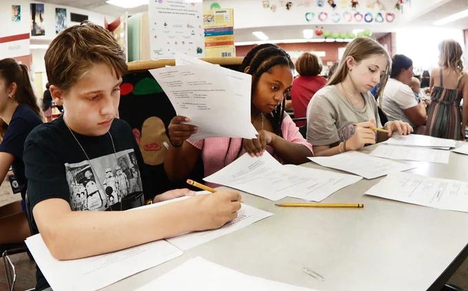 Kids filling out sheets of paper.