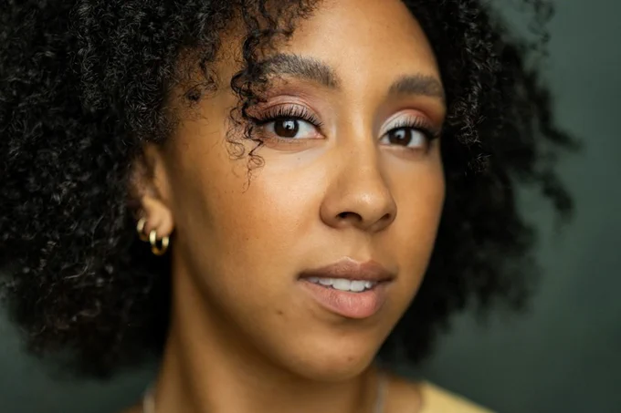A photo showing a headshot of a performer against a neutral background 