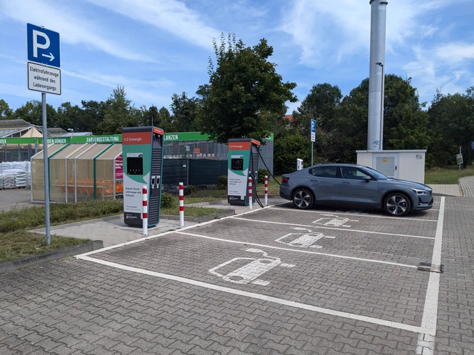 Parkplätze und Ladesäulen für Elektroautos mit einem grauen Polestar 2 vor einem Baumarkt in Leipzig